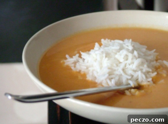 Hearty Lentil Sweet Potato Soup in a bowl, garnished with herbs