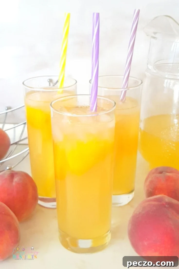 Fresh homemade peach lemonade in a glass pitcher with peach slices