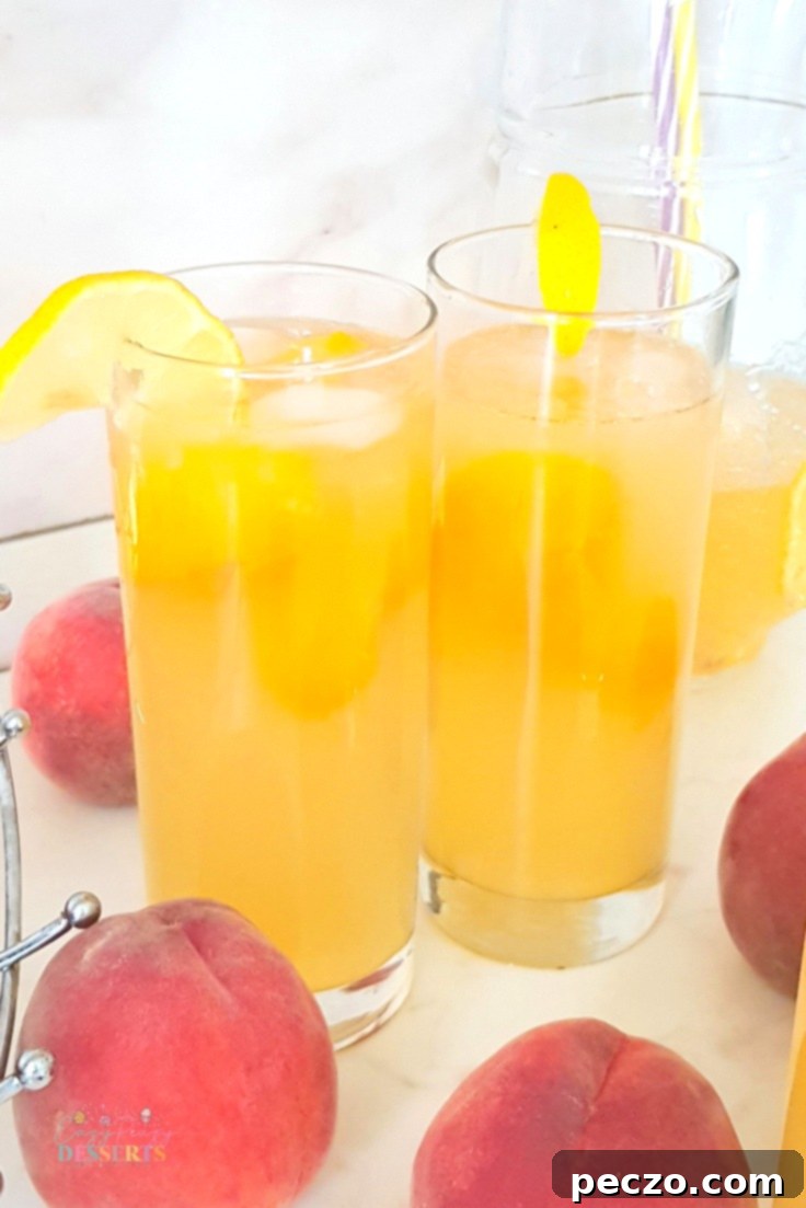 Closeup of peach lemonade with ice and peach slices in a glass
